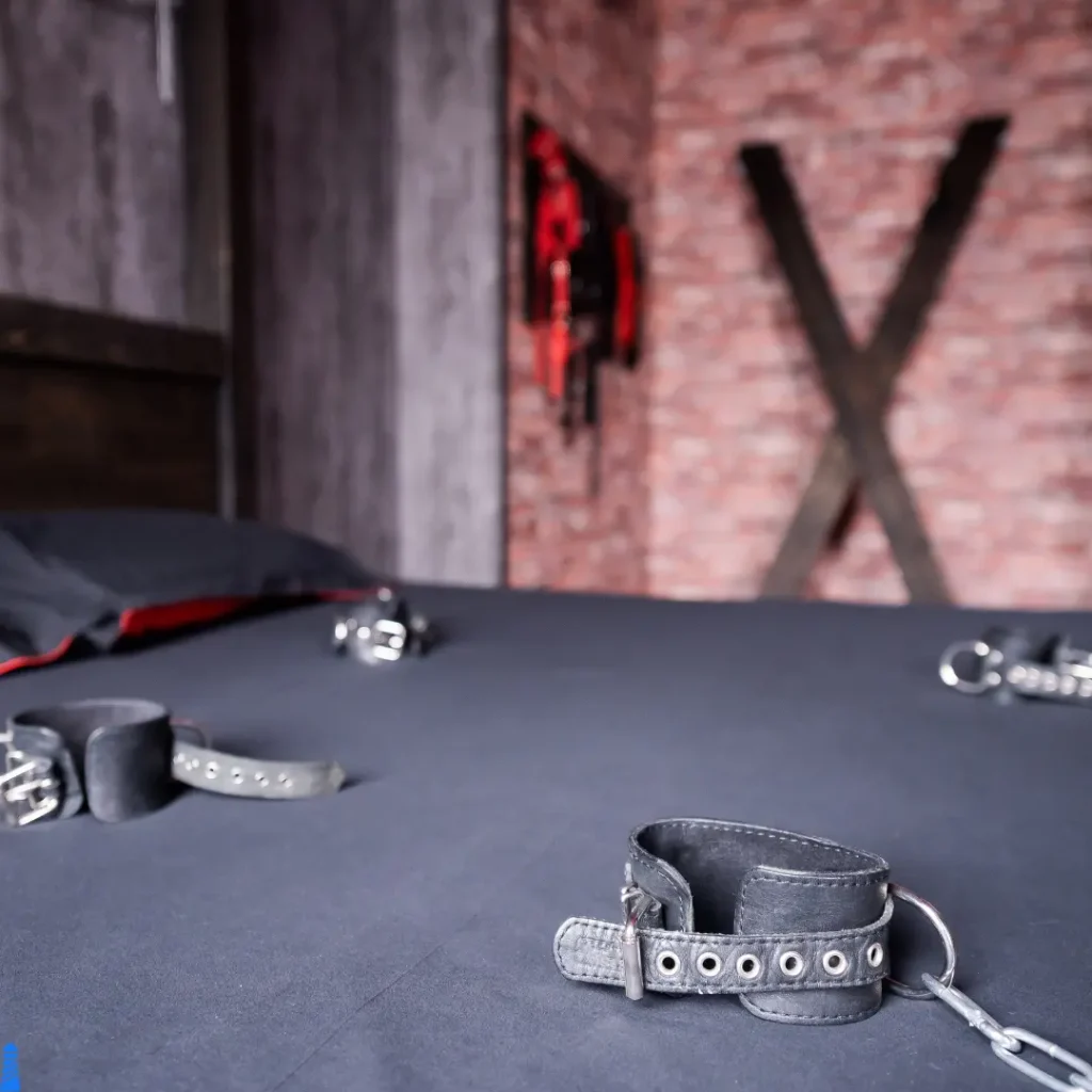 Bed with cuffs and cross in background