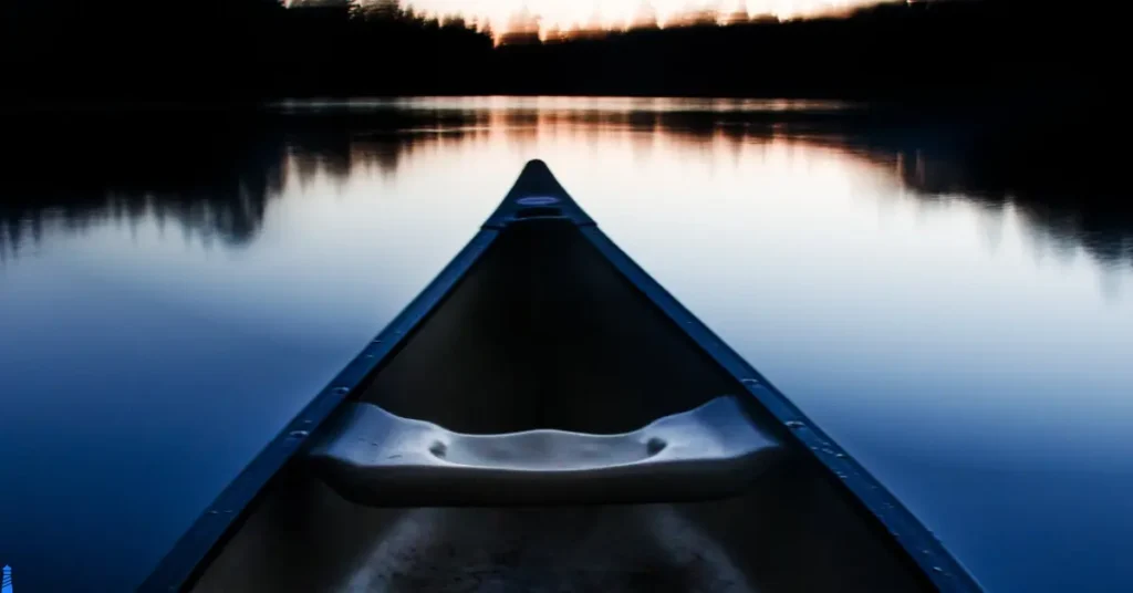 Canoe on a river in sunset's gentle light.