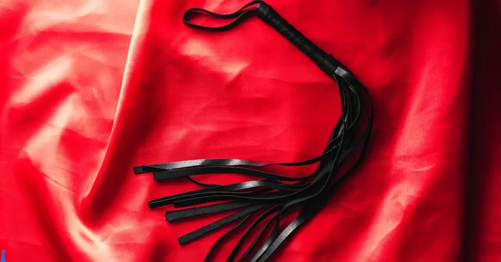 A flogger on a red background.