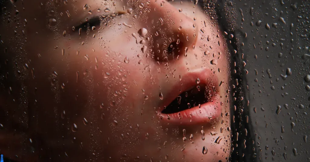 A woman through a rainy window with an oh-face