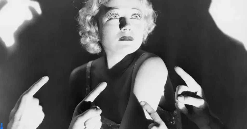 Black and white image of a woman being pointed at.