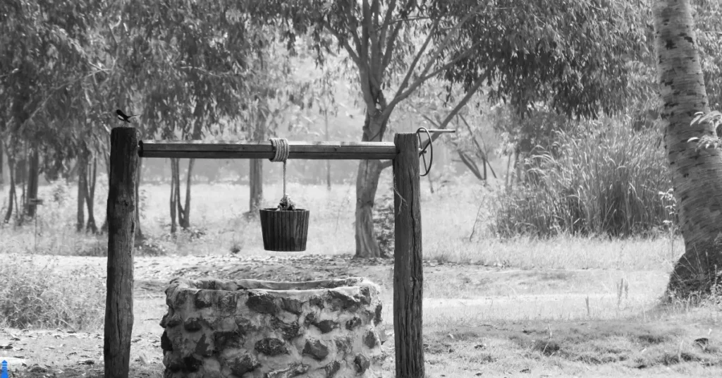 Black and white of an old fashioned well.