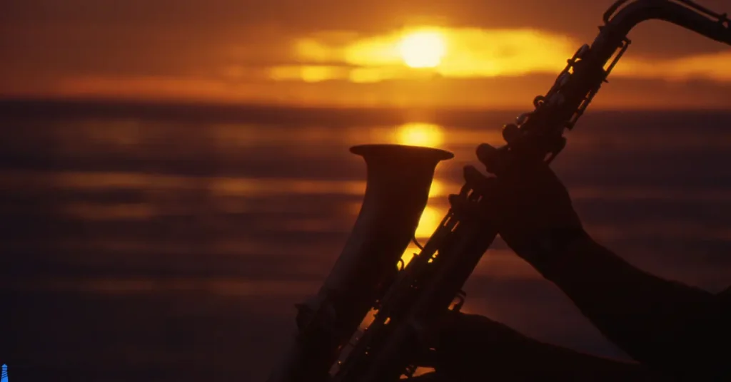 Saxophone being played with the sea behind it.