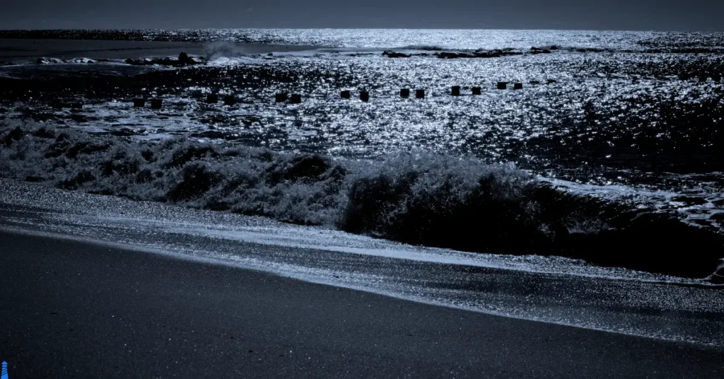 Waves crashing on a moonlit beach.